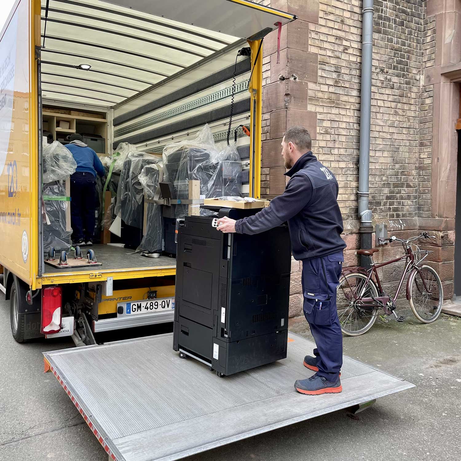 Technicien effectuant le transfert de matériel high-tech avec un camion à hayon