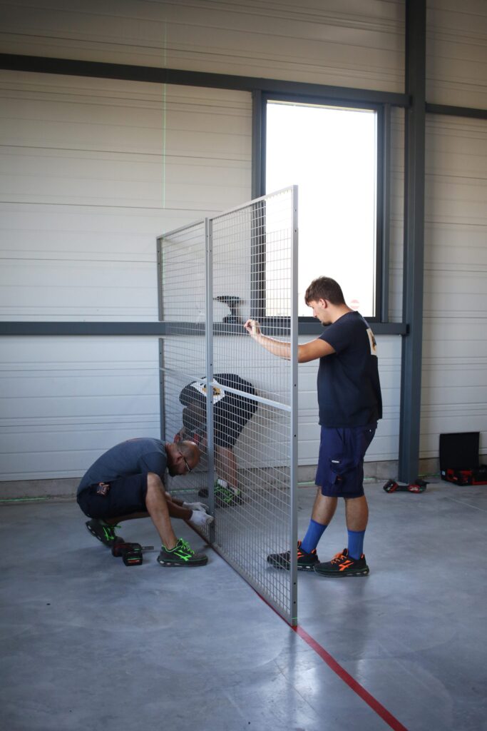 techniciens Axal effectuant le transfert et la réimplantation de box grillagés avec fixation au sol
