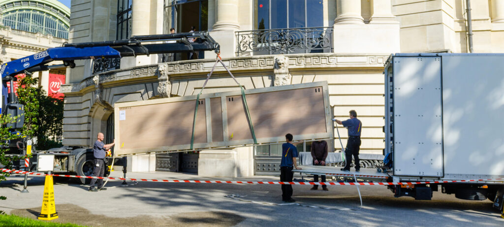Déménageurs déménageant une œuvre d'art dans une caisse de transport sécurisée