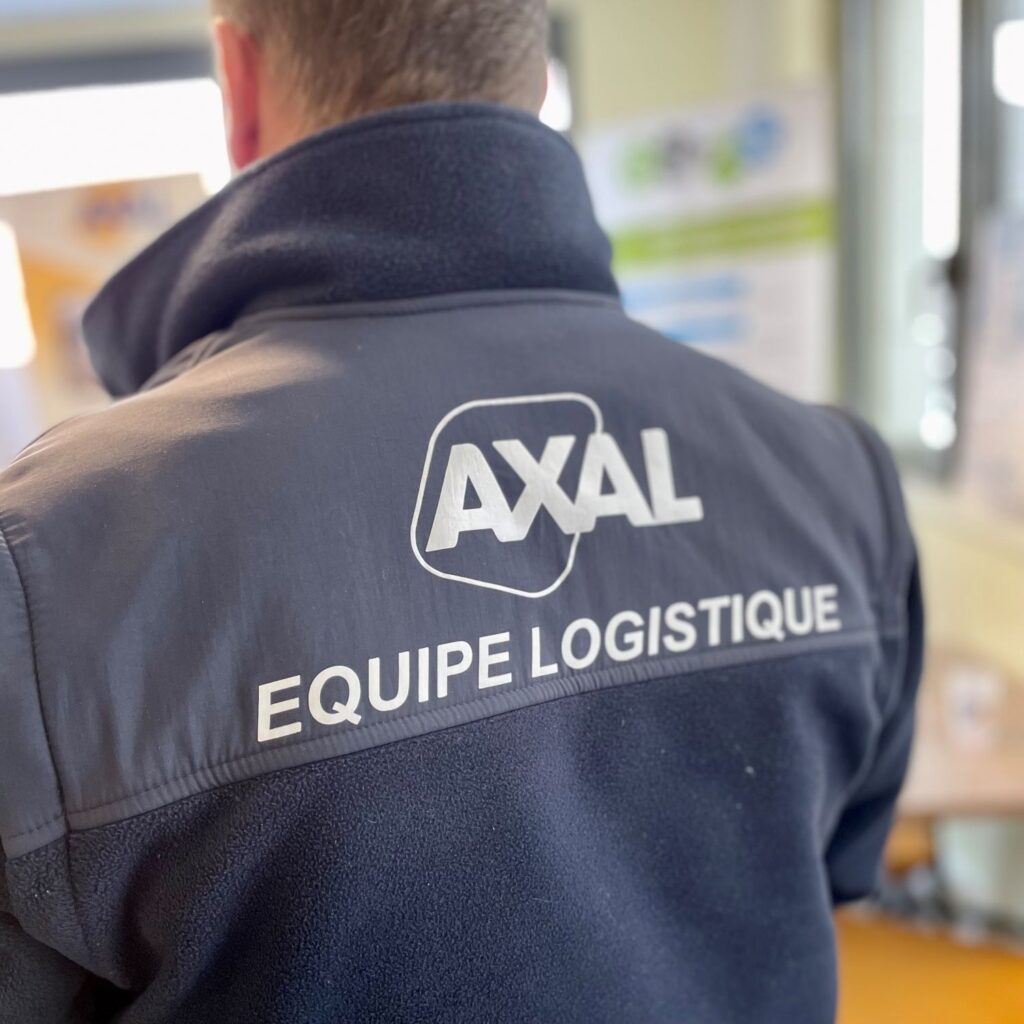 Technicien vu de dos et portant une veste avec le slogan Axal, équipe logistique
