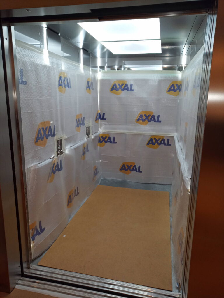 Ascenseur capitonné et bâché à l'aide de protections sur mesure lors d'un déménagement assuré par Axal