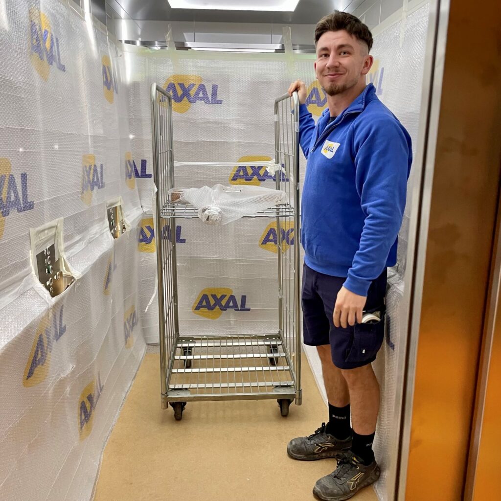 Déménageur Axal effectuant la protection de l'intérieur d'un ascenseur lors d'un déménagement d'entreprise
