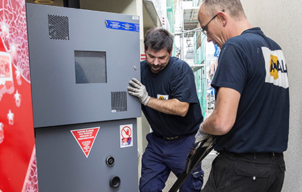 Techniciens Axal effectuant la manutention d'un DAB