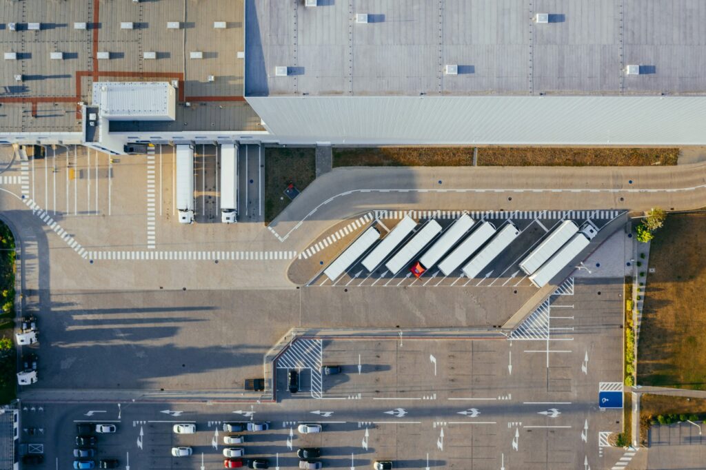 Vue aérienne d'une plateforme logistique e-commerce avec des camions de transport